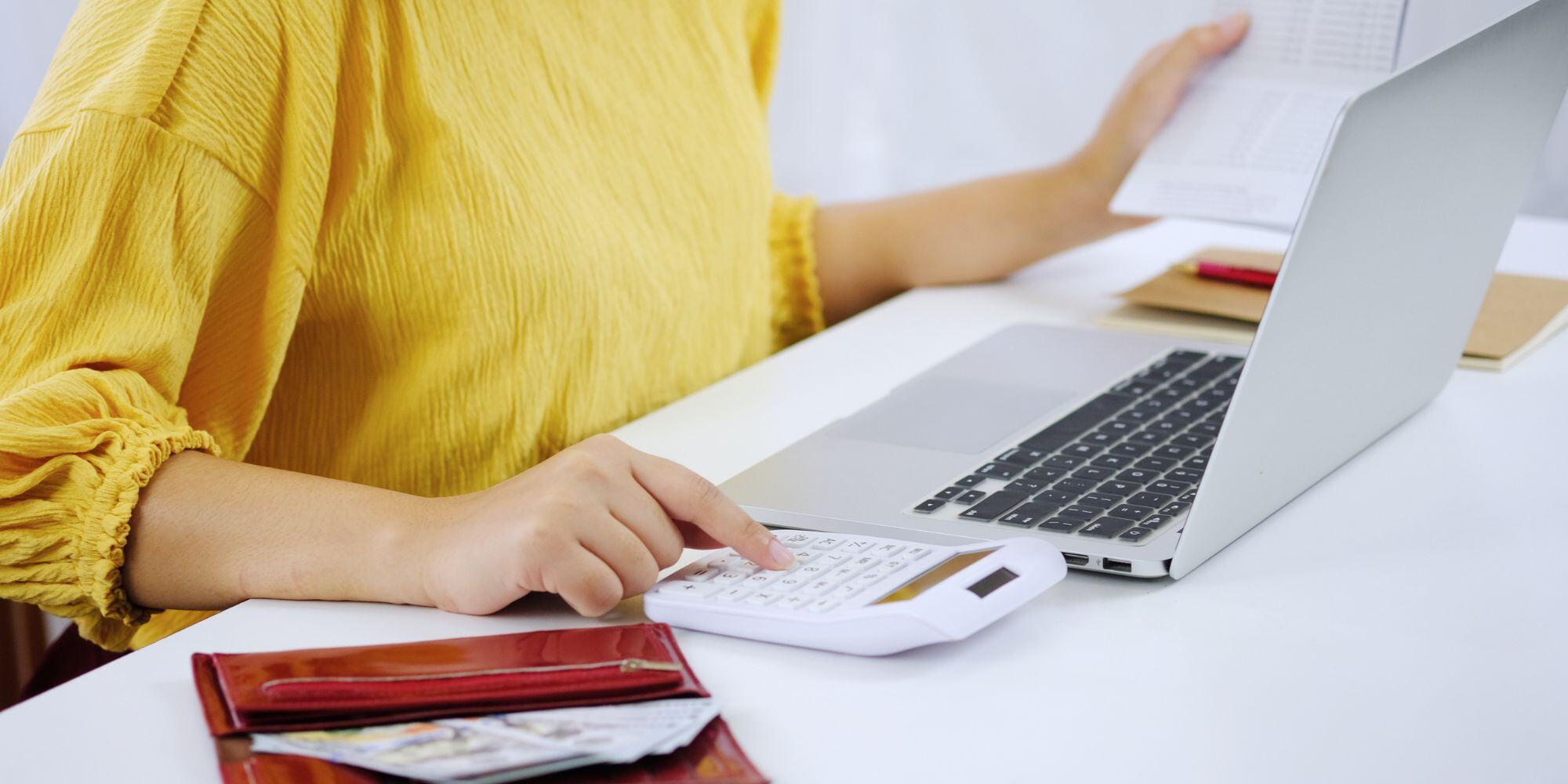 Woman Using Calculator and Laptop