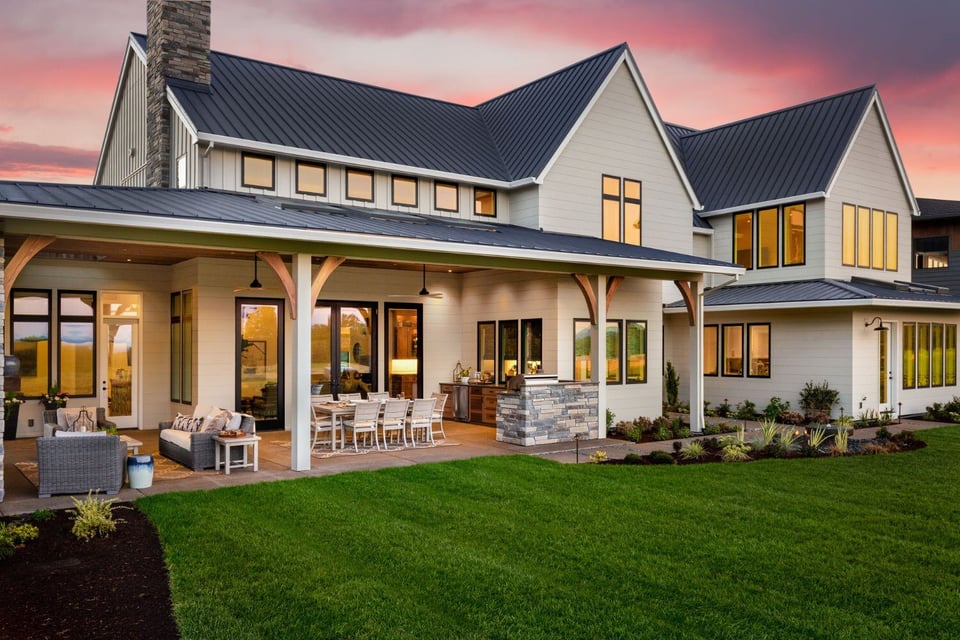 Exterior image of a large custom home with grass backyard and covered outdoor patio in Austin Texas